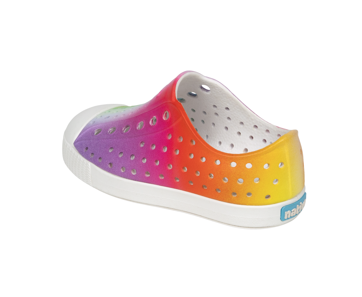 Angled view of a Native Shoes Kids Jefferson Print Kids | Shell White / Transparent / Rainbow Spray Footwear in Shell White / Transparent / Rainbow Spray