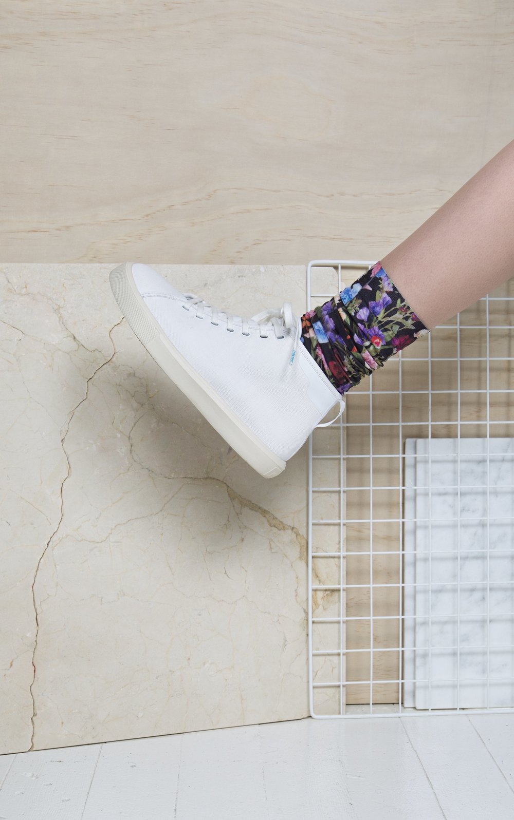  side view of white shoe on person with flower print socks