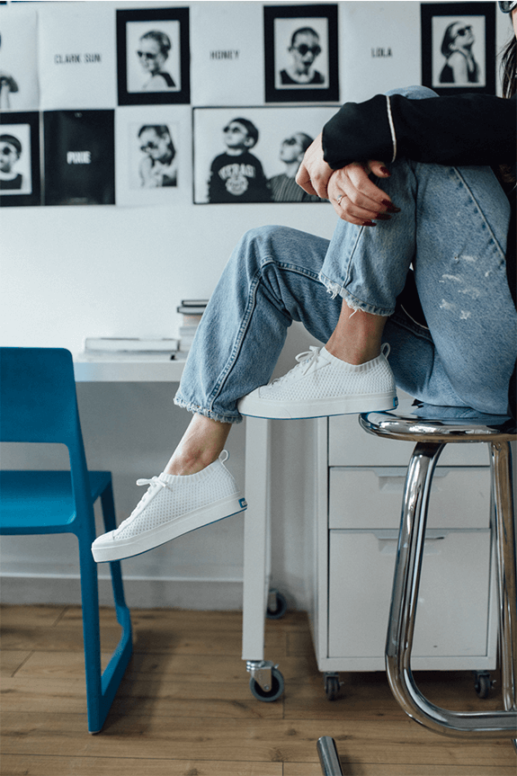 Waist down sitting on a stool wearing denim and The Jefferson 2.0 Liteknit low in white.