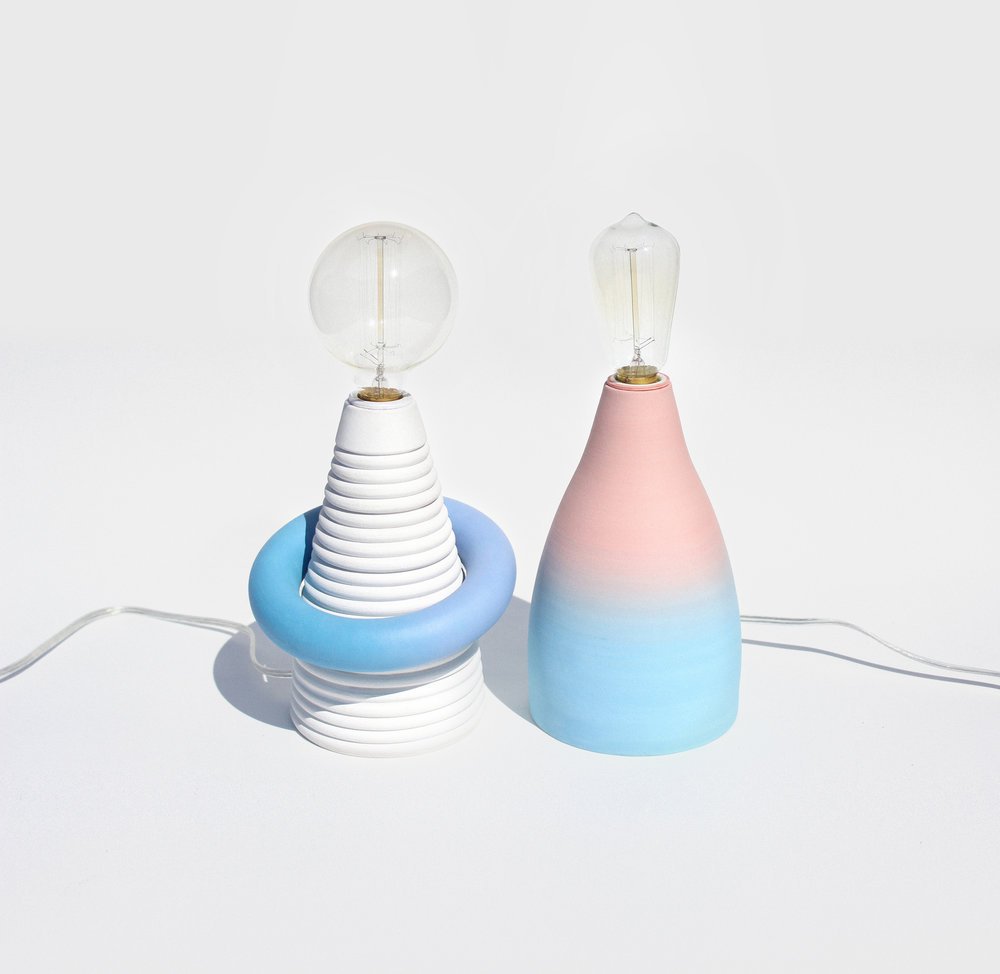 two lamps where one is white with circle bulb and another pink/blue with cylinder bulb