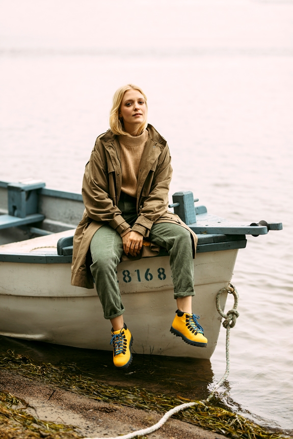 Woman sitting on a docked rowboat wearing the Native Shoes Fitzsimmons Treklite hiking boots